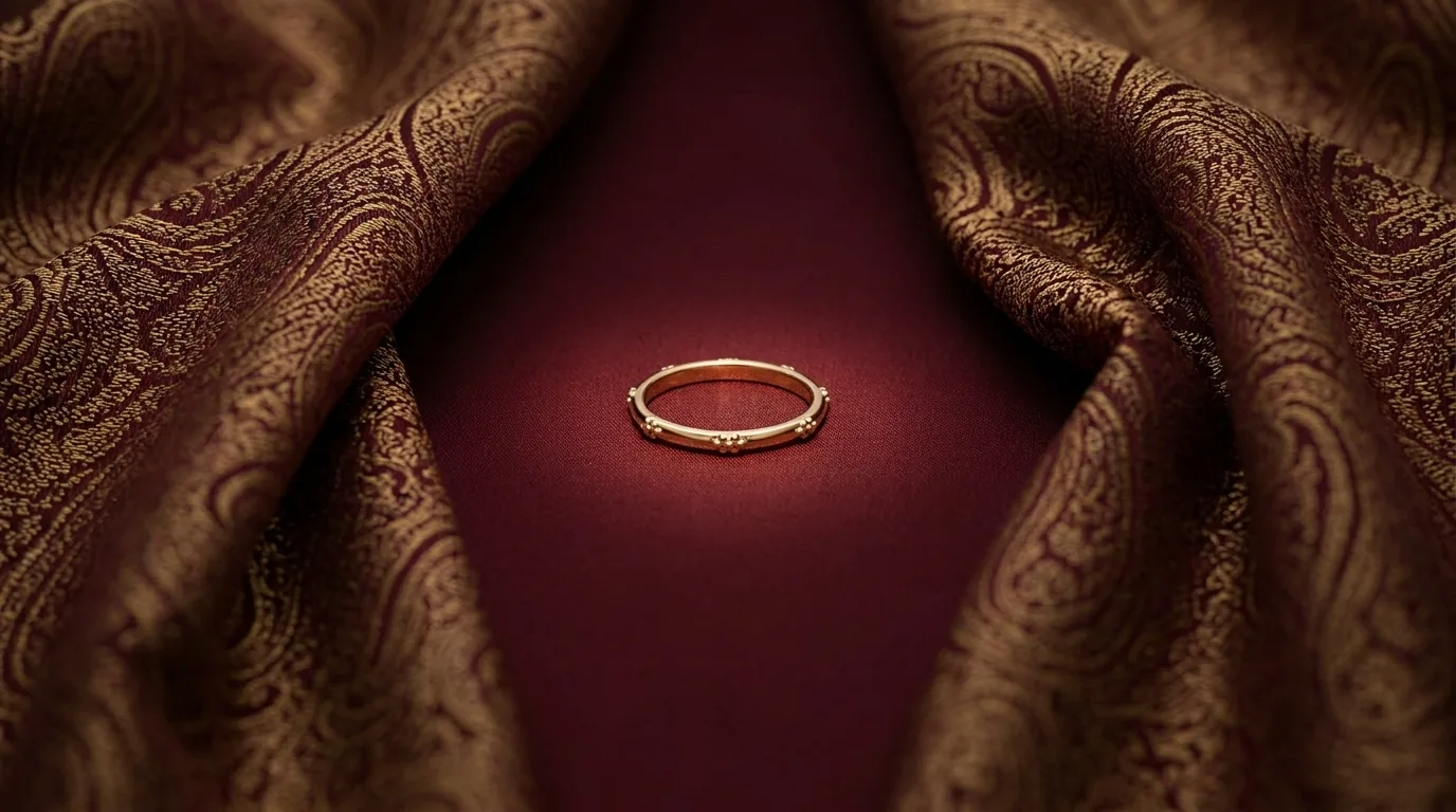 Gold stacking ring on plain claret silk framed by boteh termeh folds, how to stack gold jewellery