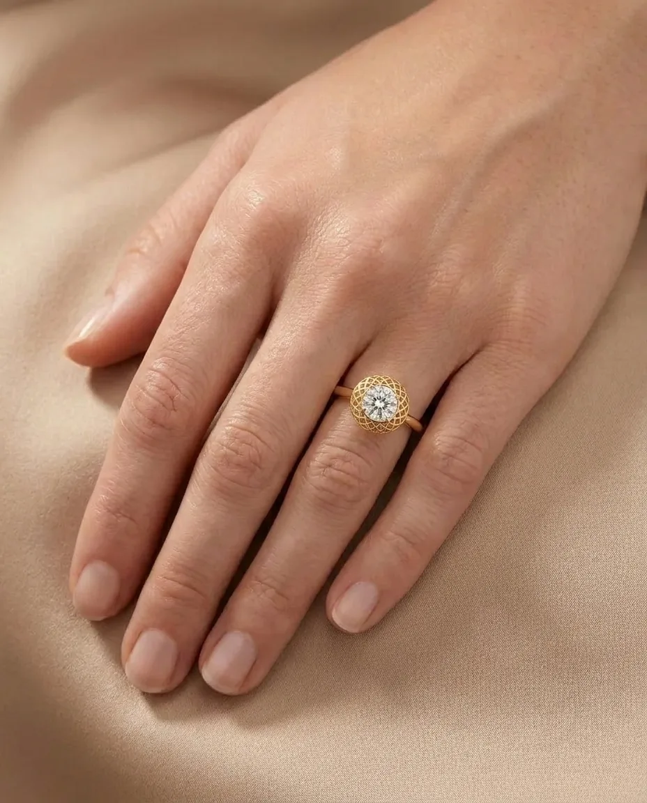 Design visualisation of the Atash Sacred Fire Lattice Halo Engagement Ring worn on the hand: a round diamond held in a flat pierced lattice halo of yellow gold.