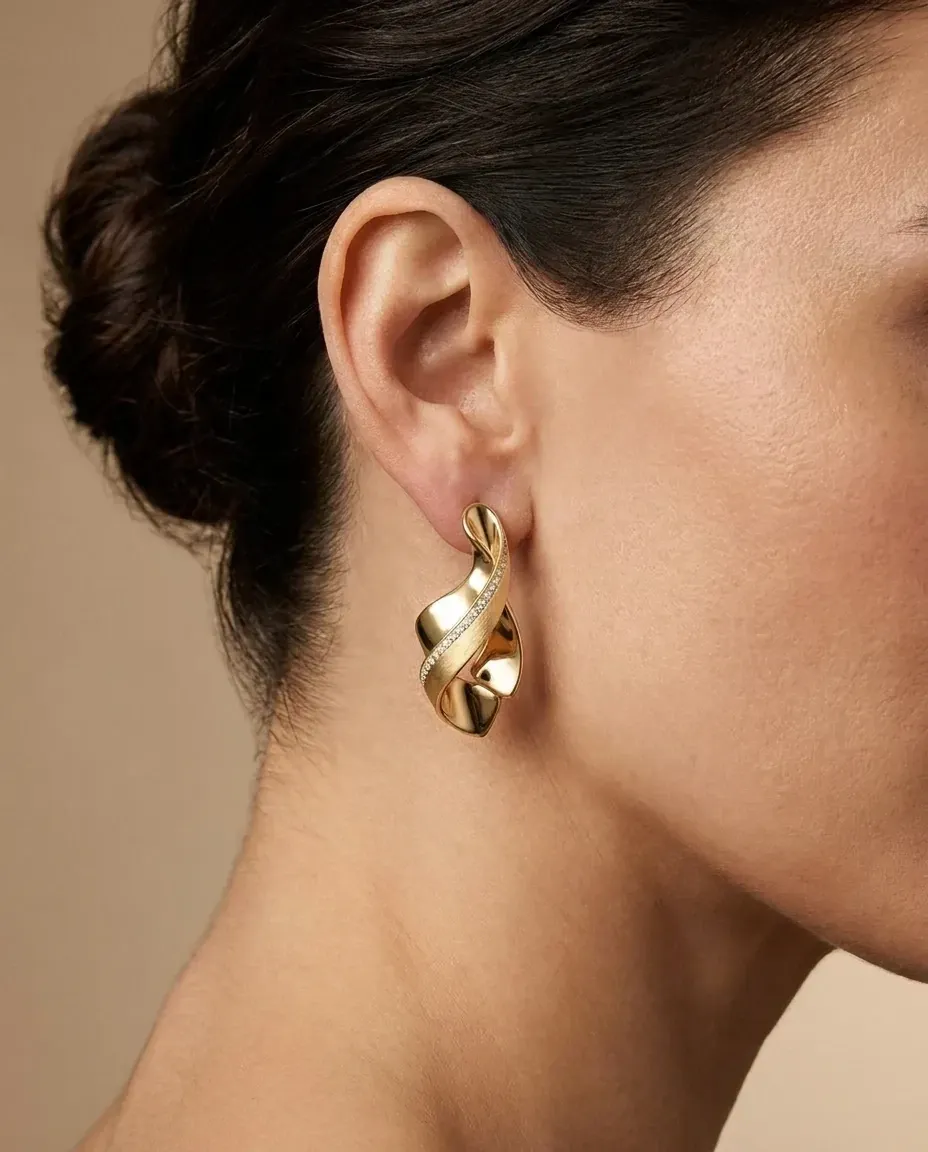 Design visualisation of a Sama Drop Earring worn through the ear: the same whirling gold sweep at a smaller scale.