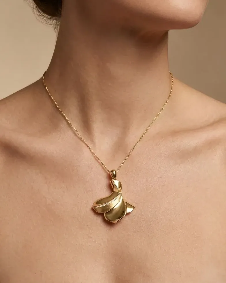 Design visualisation of the Sama Pendant worn at the neckline: a whirling gold figure with a fine diamond line, on a fine chain.