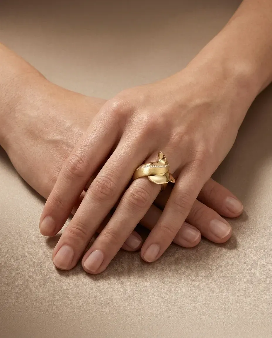 Design visualisation of the Sama Ring worn on the hand: a solid gold band sweeping into a whirling ribbon crest.